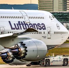 a large jetliner sitting on top of an airport tarmac next to a truck