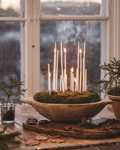 a bowl filled with candles sitting on top of a table