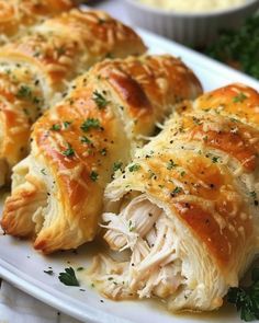 a white plate topped with rolls covered in chicken