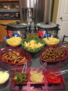 a table topped with lots of different types of food next to crockpots