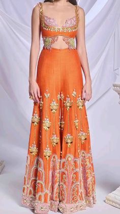 This stunning Indo-Western outfit is perfect for parties, functions or weddings! The orange butterfly shaped top and sharara set, adorned with intricate cord-set embroidery, brings elegance and festivity to your look. The matching sharara enhances the outfit’s rich, traditional feel, while the diamond choker and bold bangles add a touch of glamour. Style the ensemble with a sleek bun, subtle makeup, and a sparkling diamond ring for a chic, sophisticated vibe. golden heels tie the entire look together, making it perfect for any festive occasion.💗🌸  ✨ Follow this page for more Pinterest-inspired Indo-Western outfit ideas!✨️💖 #IndoWesternFashion #FestiveOutfit #hotLook #WeddingOutfit #PartyWear #ElegantStyle #orang3Outfit #TraditionalWithATwist #PinterestInspo Golden Heels, Subtle Makeup, Sleek Bun, Cord Set, Glamour Style, Western Outfit, Orange Butterfly, Diamond Choker, Sharara Set