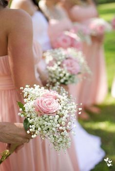 the bridesmaids are holding their bouquets with pink roses and baby's breath