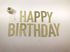 the words happy birthday are made out of gold glitter and spools of thread