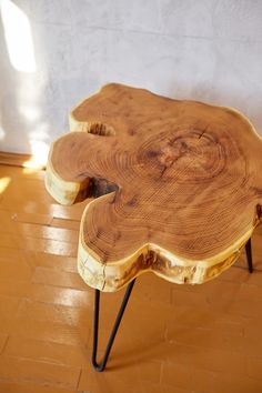 a wooden table with hairpin legs and a flower design on the top that is shaped like a tree trunk