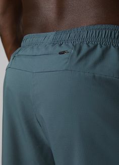 a close up view of the back of a man's body wearing blue swim trunks