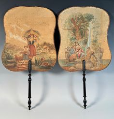 two decorative wall hangings with paintings on them