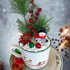 a cup filled with christmas decorations on top of a saucer