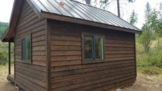 a small wooden cabin with a metal roof