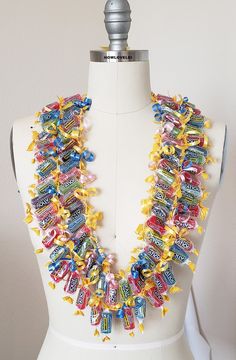 a white mannequin wearing a multicolored necklace on top of a dummy