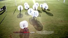 a group of people standing on top of a soccer field holding white frisbees