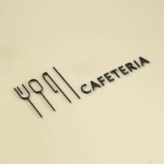 the word caferia written in black on a white surface with utensils next to it