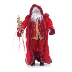 a santa claus doll holding a christmas tree ornament in his hand and wearing a red coat with gold trimmings