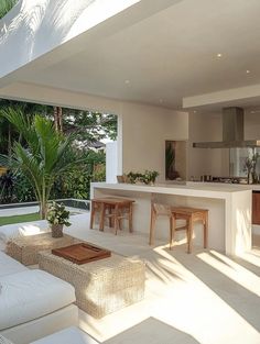 a living room filled with furniture next to a kitchen and dining area on top of a lush green field