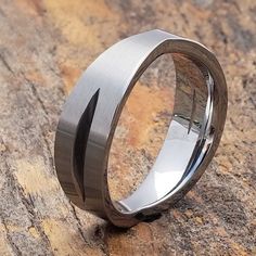 a stainless steel ring sitting on top of a rock