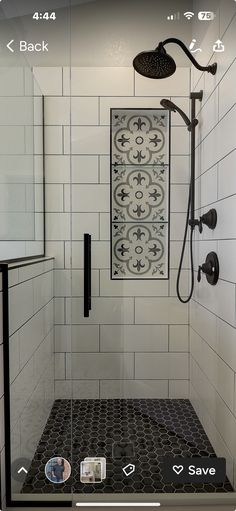 a bathroom with black and white tile on the walls, shower head, and hand held showerhead