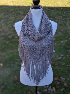 a gray scarf with fringes on top of a mannequin