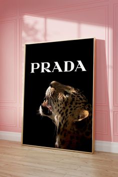 a black and white poster with the word prada on it in front of a pink wall