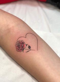 a woman's arm with a rose and a heart tattoo on the left forearm