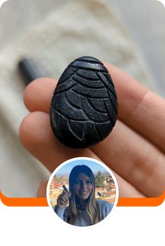 a person holding a small black object in their hand with an orange border around it