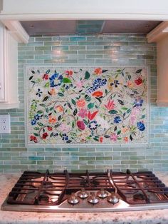 a stove top oven sitting inside of a kitchen next to a wall with flowers on it