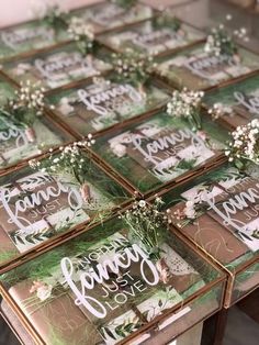 several glass trays with flowers and greenery on them are sitting on a table