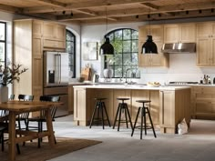 a large kitchen with wooden cabinets and stools