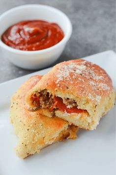 a plate with some food on it and a bowl of tomato sauce in the background