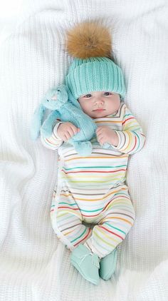 a baby is laying down with a stuffed animal