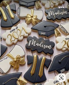 graduation cookies decorated with royal blue, white and gold icing are arranged on a table