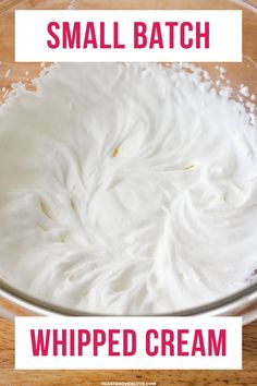 a glass bowl filled with whipped cream on top of a wooden table and the words small batch