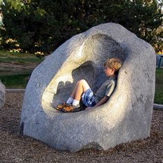 a young boy sitting in a rock shaped like a heart