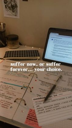 an open laptop computer sitting on top of a desk covered in notes and writing paper