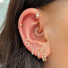 a woman wearing three different types of ear piercings