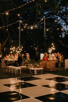 an outdoor party is lit up with string lights