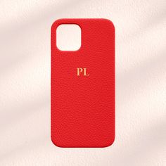 a red phone case with the word pl on it in gold lettering, against a white background