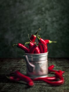 some red peppers are in a metal bucket