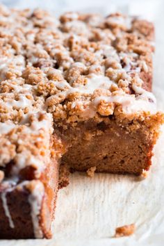 a cake with crumbs and icing sitting on top of a piece of parchment paper