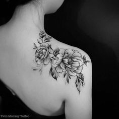 a woman's shoulder with flowers on it and leaves around the neck, in black and white