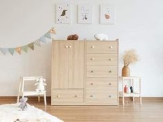 a child's room with white walls and wooden furniture, including a toy chest