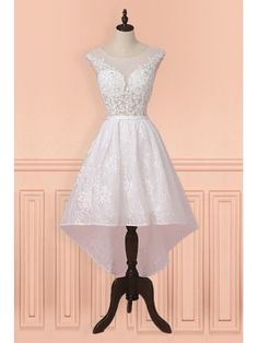 a short white dress on a mannequin stand in front of a pink wall