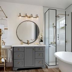 a bath room with a tub a sink and a mirror