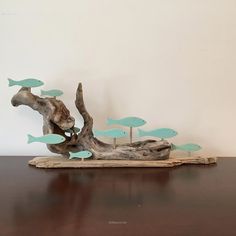 a piece of driftwood with fish on it sitting on top of a wooden table