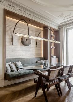 a living room filled with furniture and a glass table surrounded by wooden flooring next to a window