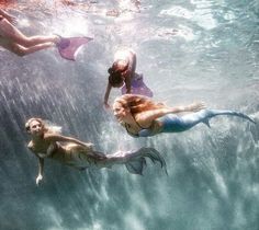 three women are swimming in the ocean together