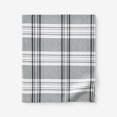 the grey and white plaid pocket square is folded on top of an unmade tablecloth