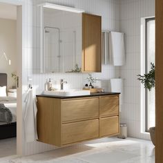 a bathroom with a sink, mirror and bathtub next to a window in the room