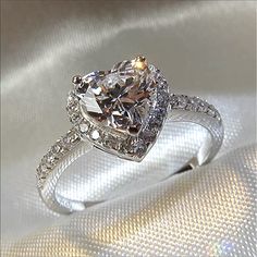 an engagement ring with a cushion cut diamond surrounded by pave diamonds