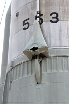 the side of a large metal structure with numbers on it and a clock at the top