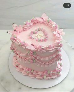 a three tiered cake with pink frosting and butterflies on it's top