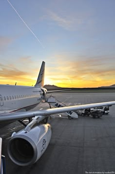 an airplane is parked on the tarmac at sunset with its landing gear down and it's engine out